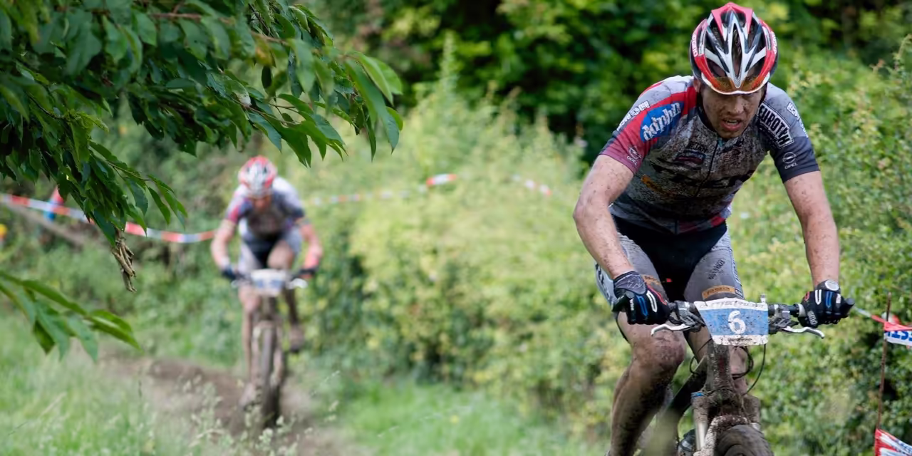 Twee mountainbikers op de fiets in de modder